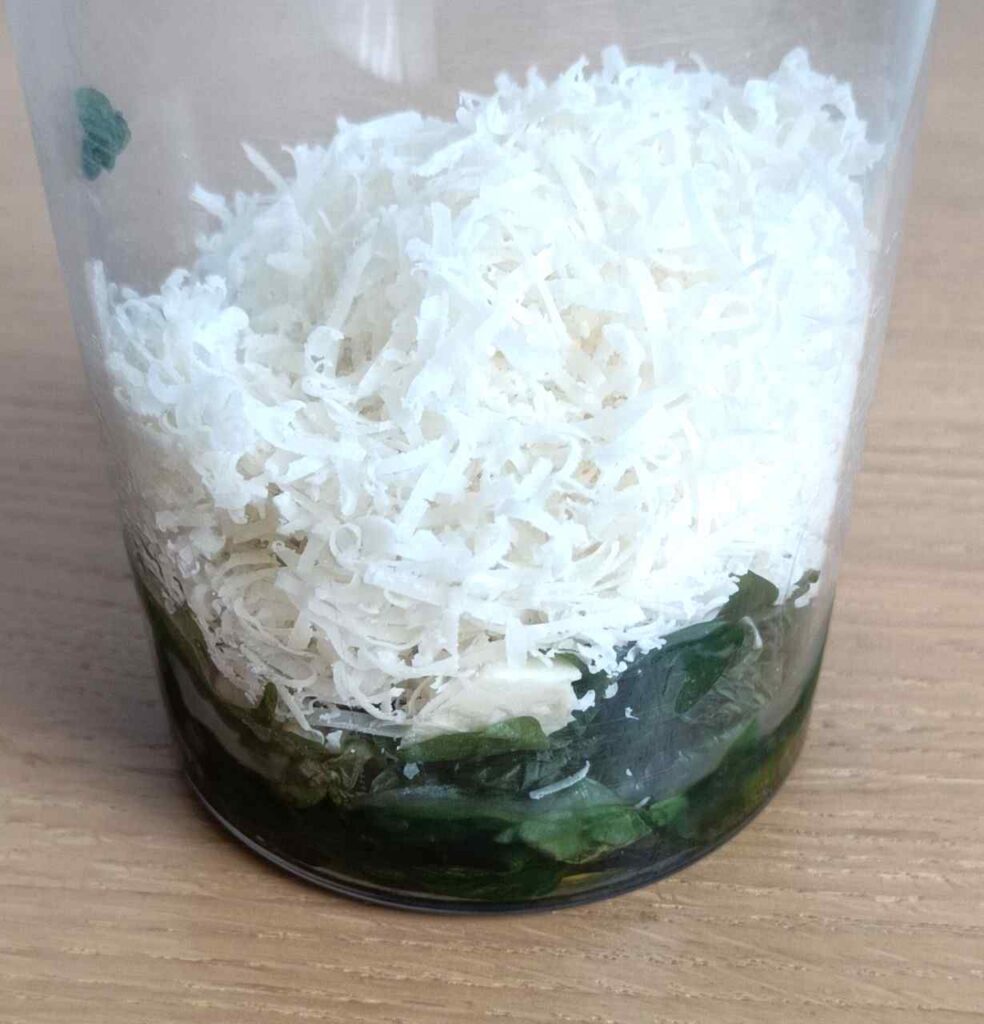 Ingredients of the Pesto Genovese, in a tall glass, ready for blending.