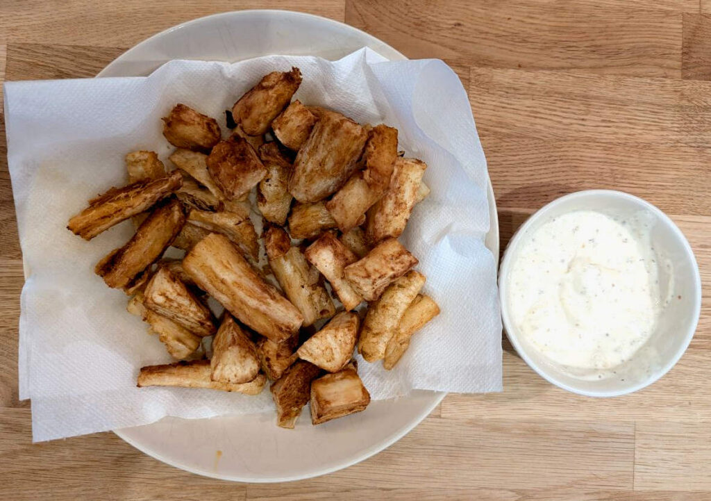 Cassava Fries in a plate, with a yogurt-based sauce next to it