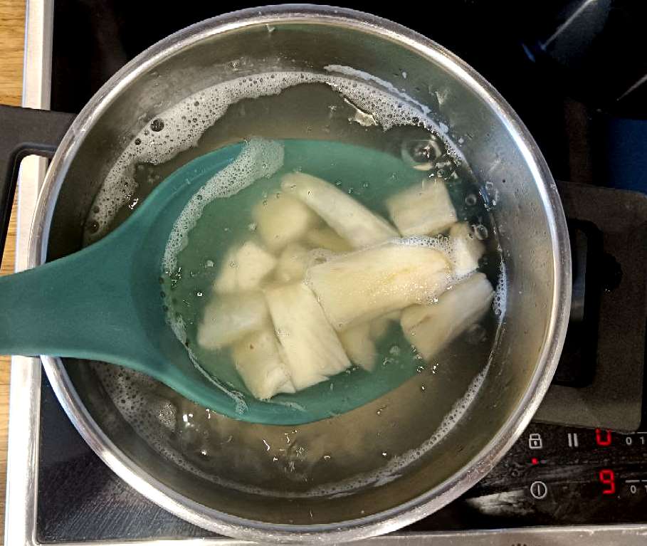 Bits of Cassava root boiling in a pot.