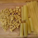Different kinds of pasta on a cutting board.